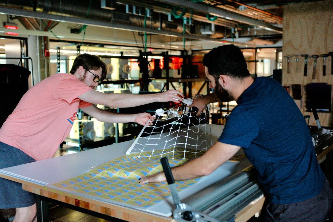 Men working on makerspace equipment. Photo/UC Marketing+Communications