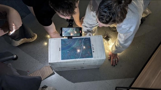 students gathered around tech